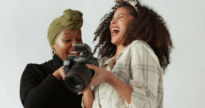 Photographer, digital camera and friends in studio shoot laughing at photograph together. Cheerful, happy and excited interracial women digital creatives on photoshoot enjoy a funny moment.
