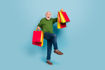 Full size portrait of delighted overjoyed funny granddad raise hold packages celebrate isolated on...