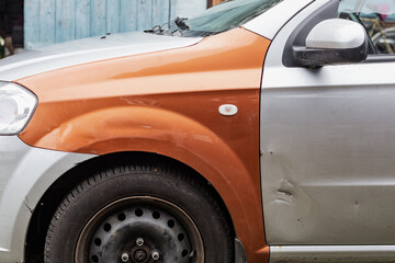 Fototapeta premium Part of a gray car damaged by fragments from military missiles, replacing wings, Ukrainian war