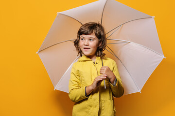 Girl looking at camera against yellow wall in studio