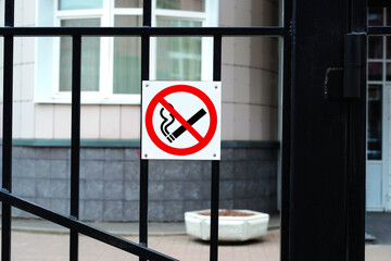 No smoking sign. Prohibition sign hanging on a gate at the entrance to a building. 