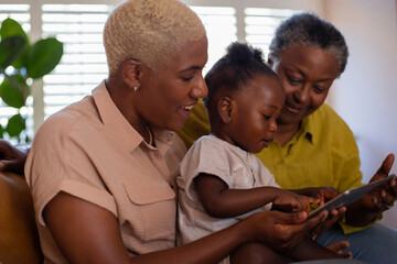 African American grandchild learning to use a digital tablet