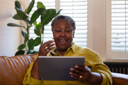 Senior African American Woman Watching Entertainment On A Digital Tablet At Home