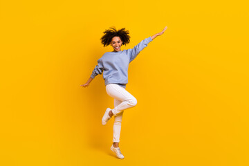 Fototapeta na wymiar Full body portrait of cheerful satisfied person jumping raise hands rejoice isolated on yellow color background