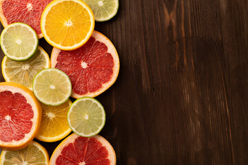 Naklejka na ściany i meble Tropical fruits cut into slices on a wooden background with copy space . Top view.