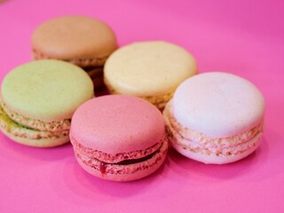 Fototapeta na wymiar Bunte Macarons aus Frankreich mit pinkem Hintergrund