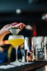 man hand bartender pouring cocktail in glass on the bar counter