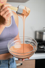 The process of tempering chocolate and making chocolates. Pastry chef using spatula tempering...
