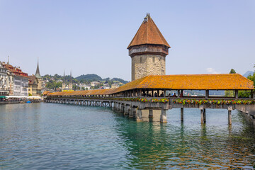 Fototapeta na wymiar LUCERNE, SWITZERLAND, JUNE 21, 2022 - View of the wodden covered Kapellbrücke Bridge on the Reuss river in Lucerne, Switzerland