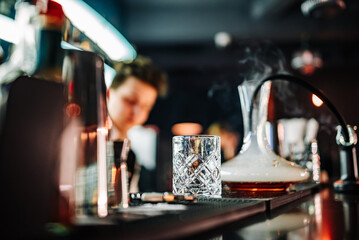 Fototapeta na wymiar bartender making cocktail in bar with smoke