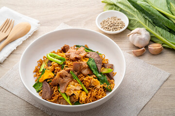 Stir-fried Instant Noodles with Soy Sauce and Pork in white plate.Asian food
