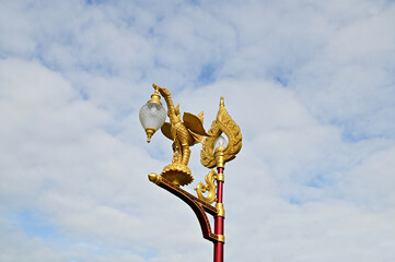 Fototapeta na wymiar The Golden Swan Street Lamp on the Blue sky background in Temple of Thailand.