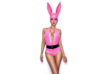 Sexy blonde woman posing in Halloween latex pink costume and pink bunny mask on white background....