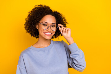 Portrait of pretty positive person hand touch glasses toothy smile isolated on yellow color background