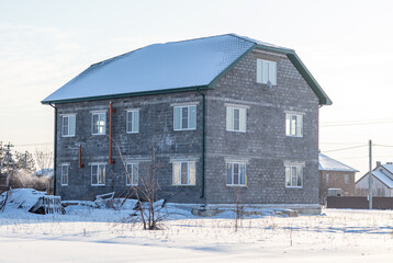 Two-storey cottage in the snow.