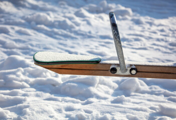 Children's swing in the snow in the park.
