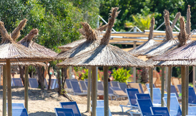Sunbeds with sun loungers on the beach - obrazy, fototapety, plakaty