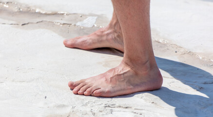 Feet of a man on a limestone volcanic rock.