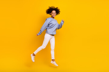 Fototapeta na wymiar Full length portrait of overjoyed excited girl jumping have good mood isolated on yellow color background