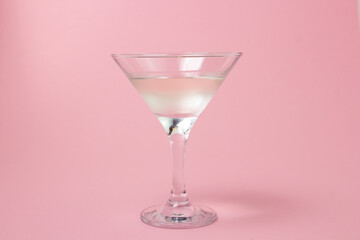 Martini glass on a pink background. Delicious alcoholic drink.