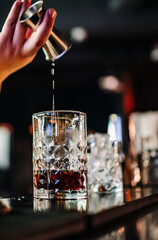 bartender making negroni cocktail in bar