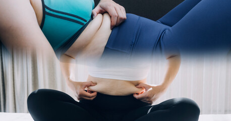 Beautiful fat woman with tape measure She uses her hand to squeeze the excess fat that is isolated on a white background. She wants to lose weight, the concept of surgery and break down fat under the