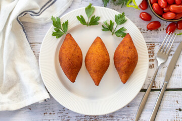 Stuffed meatballs. Turkish cuisine delicacies. Kibbeh or icli kofte on wood floor. Top view