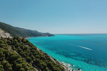 Obraz premium Seascape and sandy beach with turquoise clear waters and trees in Greece