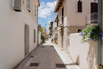 Fototapeta na wymiar Empty greek city street in light creme colours on a sunny day