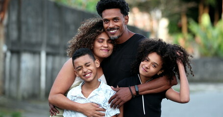 Funny African family portrait standing for photo outside. Cheerful black parents and children