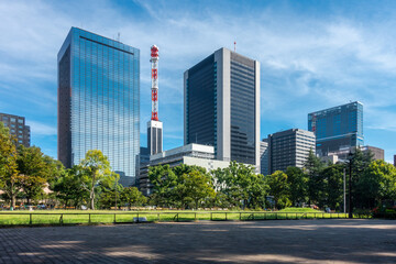 Tokyo, Japan - 09.14.2022: Modern skyscrapers in the center of Tokyo viewed from Hibiya Park. Beautiful sunny day in the downtown of Japanese capital.