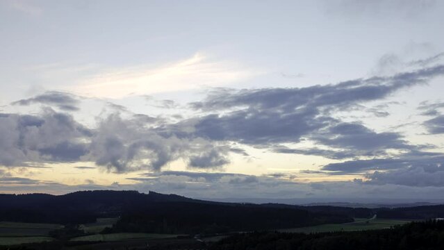 Time lapse shot of forests and meadows of plateau region Baar between Black Forest and Swabian Alps on a cloudy evening in late summer seen from hill &bdquo;Hohenlupfen&ldquo;