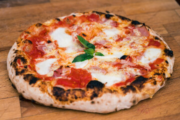 Homemade neapolitan pizza on rustic wooden board ready to eat.