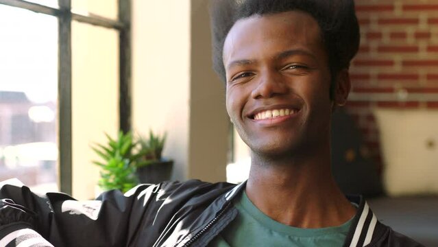 Happy, Smile And Black Young Man On World, Global Or International Travel Relax In Hostel Living Room. Funky Hair, Gen Z And Peace For Retro African Person Or Student Relaxing In New York Apartment