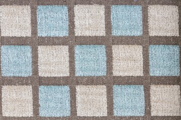 Closeup shot of a blue brown square patterned fabric textile surface