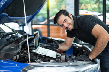 Mechanic Asian Arab man close up using laptop computer and diagnostic software to tuning fixing...