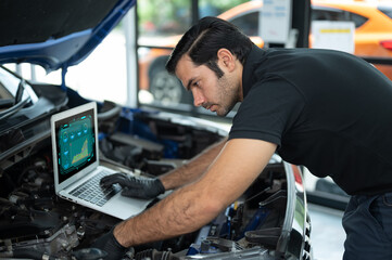 Fototapeta na wymiar Mechanic Asian man close up using laptop computer and diagnostic software to tuning fixing repairing car engine automobile vehicle parts using tools equipment in workshop garage support service
