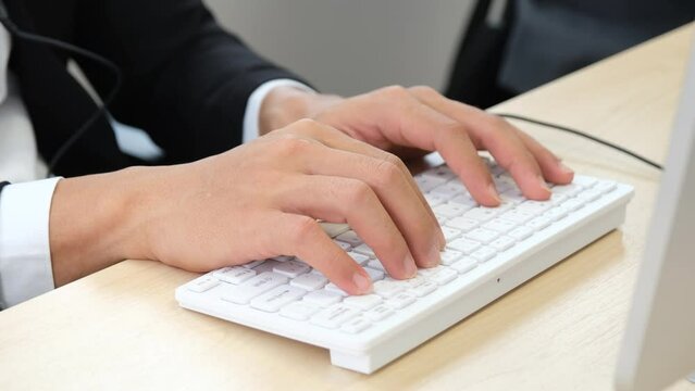 man's hand typing fingers on white keyboard