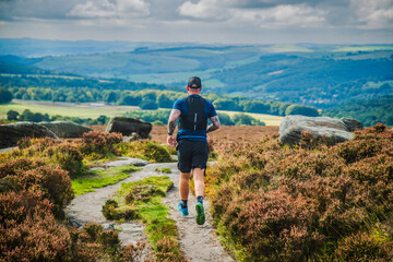 Fell runner descending from Burbage Edge in the Peak district