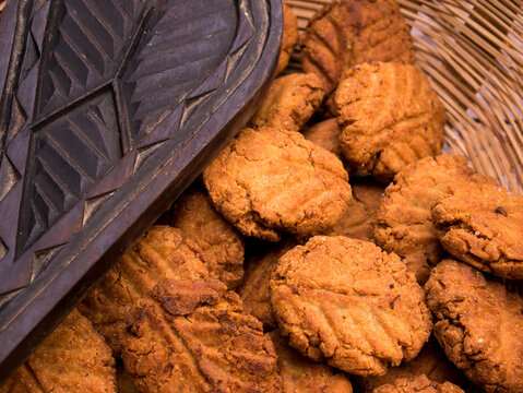 Thekua , an Indian sweet dish or a snacks in bamboo or wooden basket or tokri with mold in wooden table. popular in bihar jharkhand. Prashad in chhath maha parv or puja or festival. selective focus.