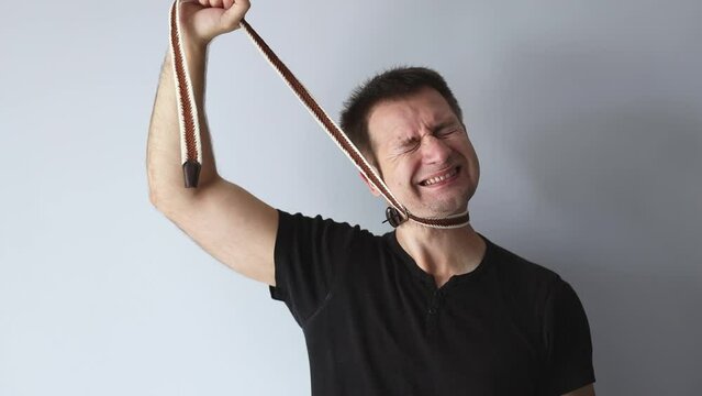 World Mental Health Day. Man in black t-shirt strangles himself with rope