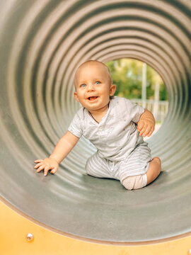 Happy cute beby boy playing on the playground