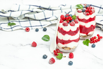 yogurt granola parfait with blueberry and raspberry on a light background. Long banner format