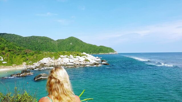 Santa Marta Colombia , Tayrona Natural Park Caribbean sea Cabo San Juan  - Drone aerial view blond lady girl looking the amazing  sand beach and bay with  forest during the travel in South America