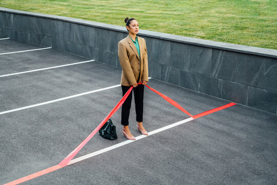 Businesswoman pulling red line at parking lot