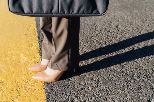 Businesswoman wearing brown stilettos on yellow line