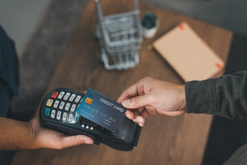 Customer using credit card for payment to owner at cafe restaurant, cashless technology and credit card payment concept