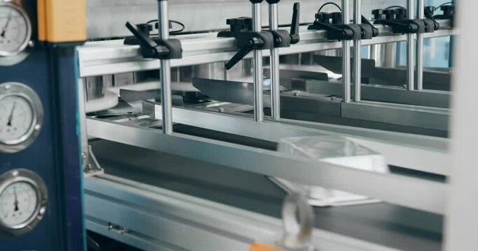 Production of foil food trays at the factory. Pressing machine on factory line making food containers from recycled aluminum