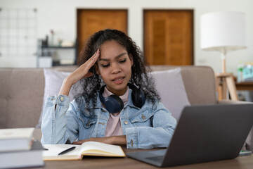 Exhausted african-american businesswoman having headache in office. Bored young african girl tired of learning sit at home looking at laptop, apathetic black female university student frustrated.
