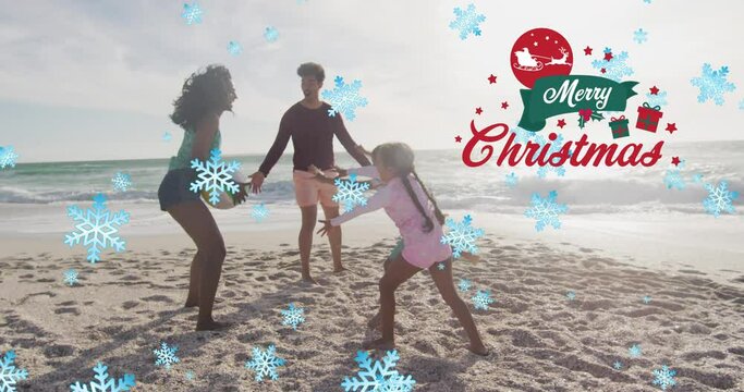 Animation Of Merry Christmas Text And Snow Falling Over Biracial Family At Beach